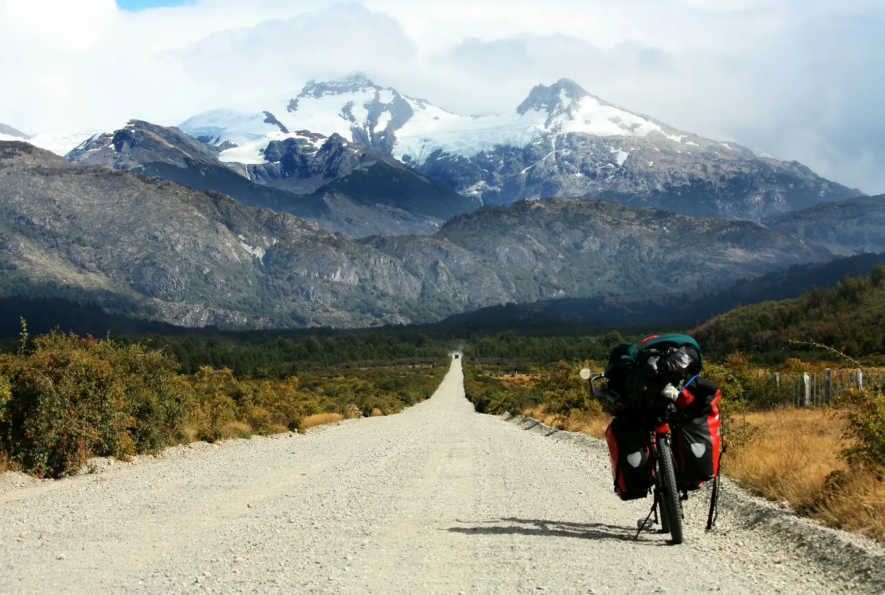 A bike touring setup with panniers parked beside a Patagonian mountain trail