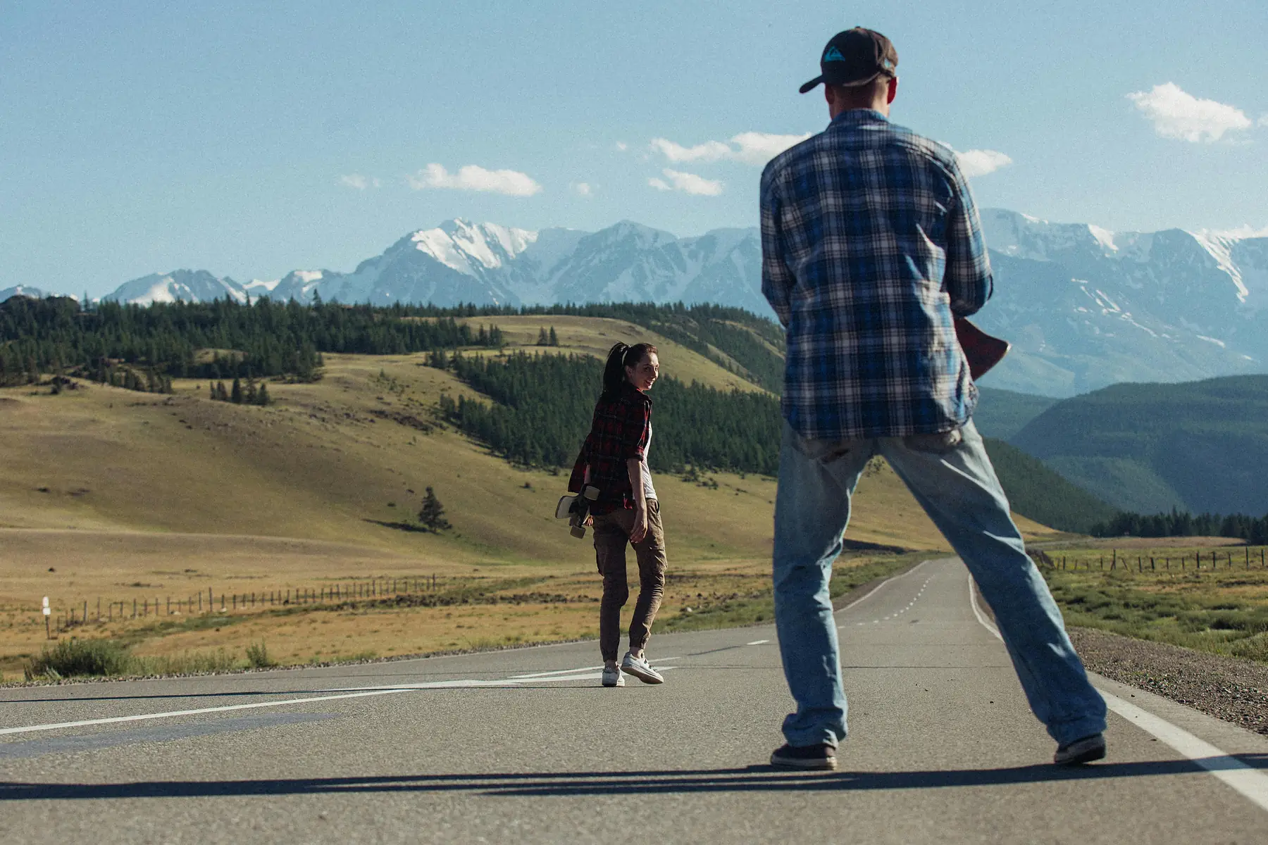 An empty gravel road stretching across the Patagonian steppe toward the Andes.